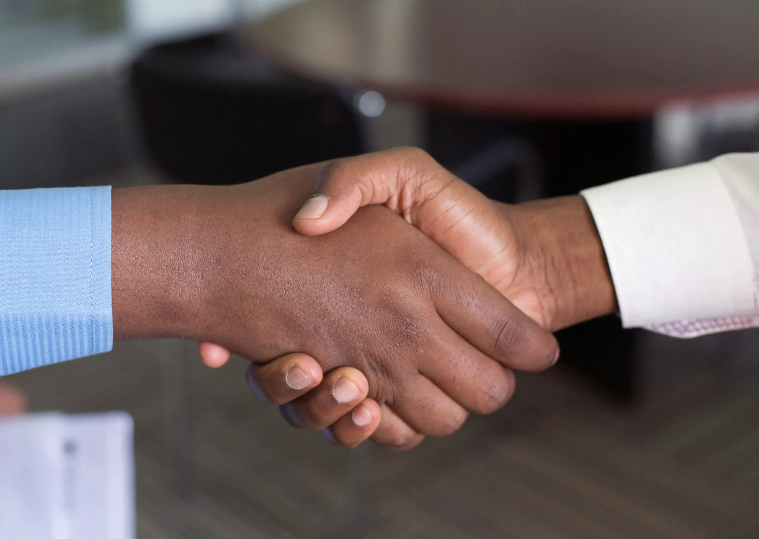 Behring Blog How to Convert an H-1B to an EB-5 Visa Img1 Two men shaking hands after a successful EB-5 path to permanent green card status.